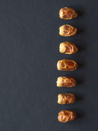 Sagai dates are laid out on a black table.の写真素材