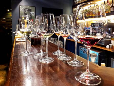 Glasses of elite wine on the bar in a dark interior.の写真素材
