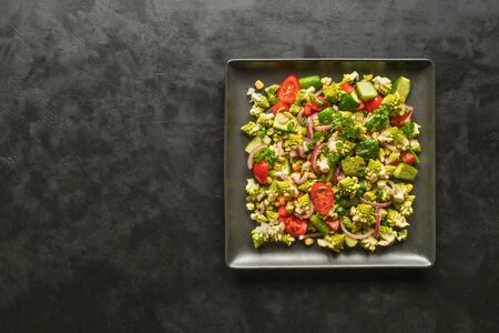 Organic vitamin salad with romanesco cabbage on black table. Asian food.