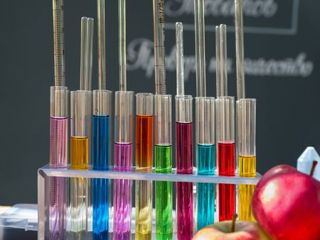 Test tubes with a colored reagents in a rack.