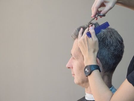 Man in barber chair, hairdresser haircut his hair. Barber shop.の写真素材