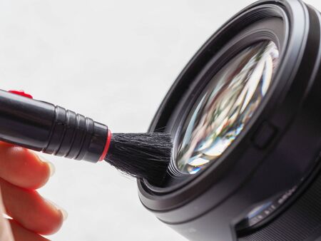 Cleaning the camera lens with a special brush. Close up.の写真素材