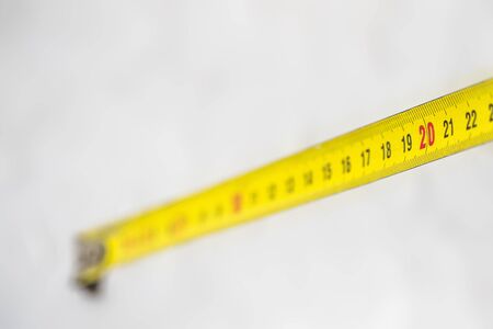 Yellow measuring tape with size 20 on white background. The concept of discounts.の写真素材