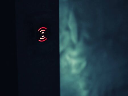 The red touch button glows on a black background.の写真素材