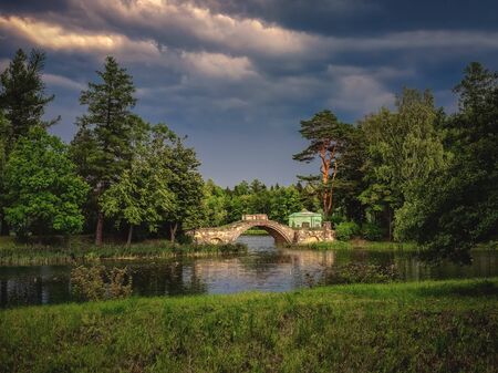 Stormy landscape with old stone bridge in the Parkの写真素材