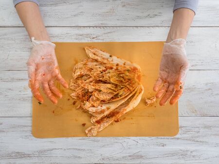 Gloved hands prepare Korean kimchi. Top viewの写真素材