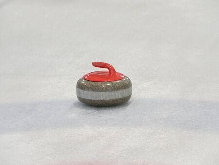 curling rocks on a white and blue rinkの写真素材