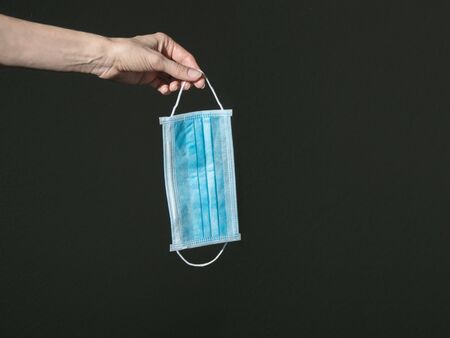 Medical bandage in hand on a dark background. Virus protection concept.