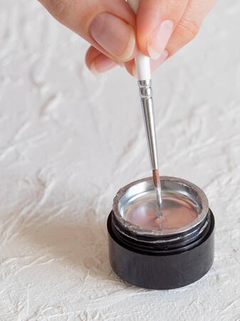 A thin brush in silver paint. Close up.の写真素材