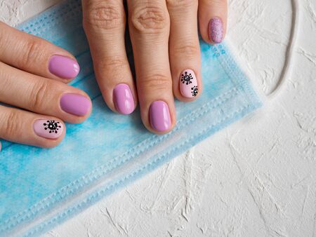 Creative manicure with painted coronavirus on the nails.
