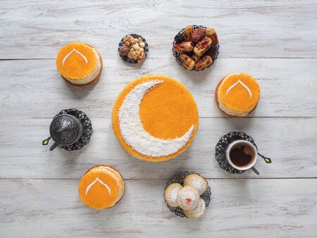 Delicious homemade golden cake with a Crescent moon, served with black coffee and dates. Ramadan background.の写真素材