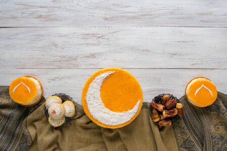 Festive food Ramadan background. Delicious homemade golden cake with a Crescent moon, served with dates. Top viewの写真素材