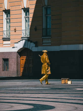 Golden painted artist on a city street, living statues is the entertainment for passerby. Saint-Petersburg. Tinted image.の写真素材