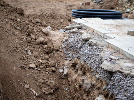 Broken asphalt and a pit, road works. Road repair, excavate the roadway with asphalt pavement and paving stones.の写真素材