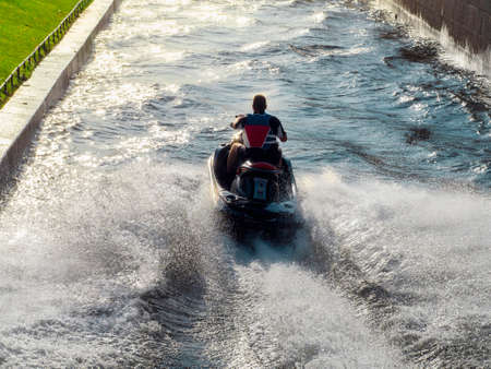 People ride on a water bike in the city river in Saint-Petersburg.の写真素材