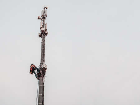 A high-rise worker works on a cell tower.の写真素材