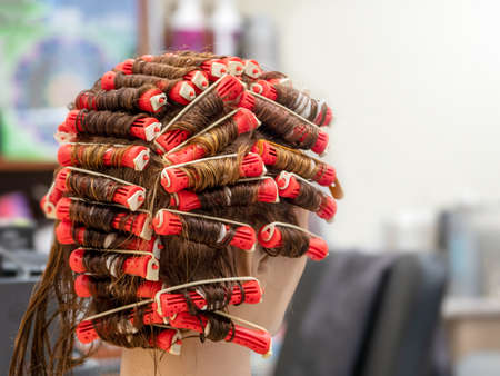 Perm training on a mannequin at the school of hairdressing.の販売画像