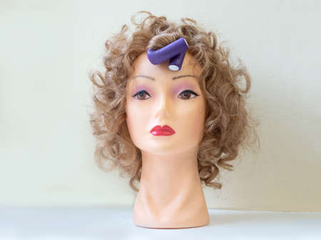 Flexible curlers on the mannequin's head.