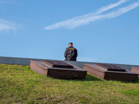 Male security guard sitting on the street with his back. Translation of the inscription on the back: Security.の写真素材