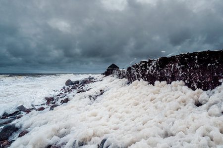 Evening polar landscape with an old dilapidated house on a rocky shore. Winter Teriberka.