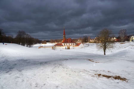 Sanny spring view of the old palace. White snowy landscape with old Maltese palace in beautiful natural landscape. Gatchina. Russia.のeditorial素材