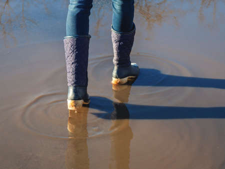 Ice-crusted ground, a woman walking on a slippery street, spring weather. Icy conditionsの写真素材