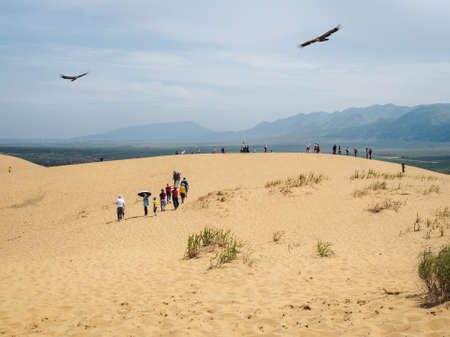 Russia. Dagestan. Sarykum dune. May 2021. A group of tourists enjoy the views after climbing a sand dune.のeditorial素材