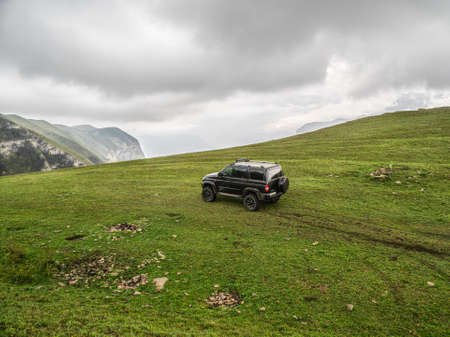 Russia. Dagestan. Hunzah. May 2021. Off-road Uaz patriot vehicle on the edge of a steep cliff....