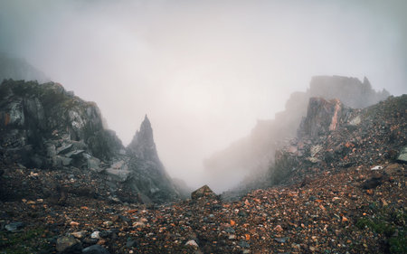 Beautiful panoramic mountain landscape with red snow rocks. Big rock formation, different rock formations and soil layers. Distant mountain plateau.の写真素材