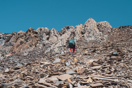 Man lying down in nature and resting. Happy male tourist after climbing lies and rests on the green grass against the background of the mountains.の写真素材