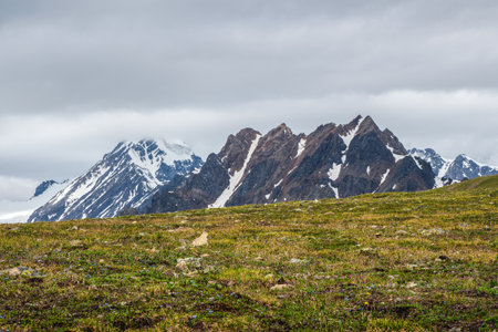 Alpine highlands. Scenic mountain landscape with changeable weather in highlands. Sunlight and shadow. Texture of the Alpine green slope.の写真素材