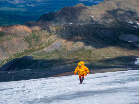 Male climber drinks water on a snowy mountainside while climbing.の写真素材