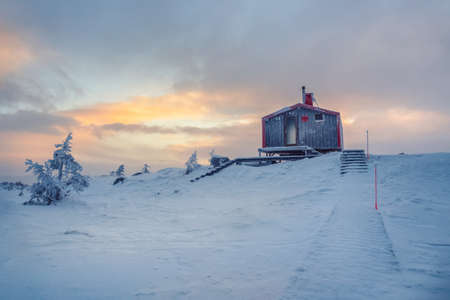 Dramatic alpine landscape with abyss and high mountain range with flying bird under cloudy sky. Colorful scenery with sharp rocks near precipice edge and large mountain ridge at changeable weather.の写真素材