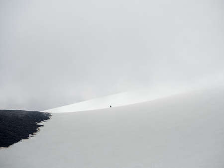 Minimalistic scenery with small two hikers on the glacier. Extreme recreation and mountain tourism....