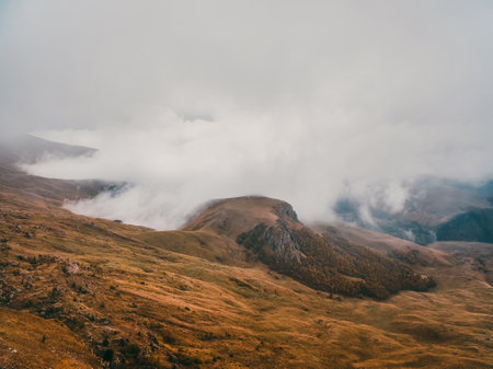 Wonderful alpine scenery with great plateau and mountains in dense low clouds. Atmospheric highlands...