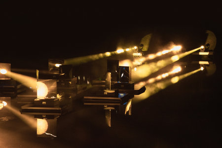 Beautiful laser lights, yellow laser in the smoke is reflected from many mirrors, an abstract play...