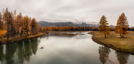 Wide flood of the river. Beautiful misty mountain landscape with wide Argut river. Gloomy scenery with big mountain river in mist. Dark atmospheric view to great river among mountains in rainy weatherの写真素材