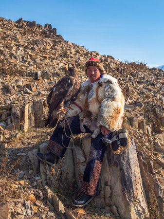Ulgii, Mongolia - September, 30, 2023: Portrait of an experienced male hunter with a hunting golden eagle at a competition. Eagle hunters are people who train and hunt with golden eagles in Mongolia.のeditorial素材