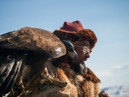 Ulgii, Mongolia - September, 30, 2023: Northern Mongolia. Portrait of an old male hunter with a hunting golden eagle. Eagle hunters are individuals who train and hunt with golden eagles in Mongolia.のeditorial素材