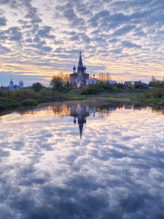 View of the Dunilovo village. Annunciation Monastery, Ivanovo region, Wide river, horizon, clouds are reflected in the water. Morning landscape, sunrise on the river.の写真素材