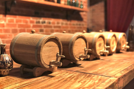 Selective focus. Wooden barrels for alcohol with wooden wings. Old wooden wine barrels stacked in a...