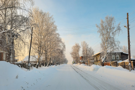 Slippery winter road. Winter evening village. Winter road through a snow-covered village, severe frost, snow haze. Perm Region, the hinterland of Russia.の写真素材