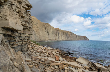 Huge layers of granite and rock on the sea coast. Tolstiy or Fat cape in east of Crimea and rocky shoreline of Black Sea. Stone coast with volcanic rocks in perspective with a horizon.の写真素材