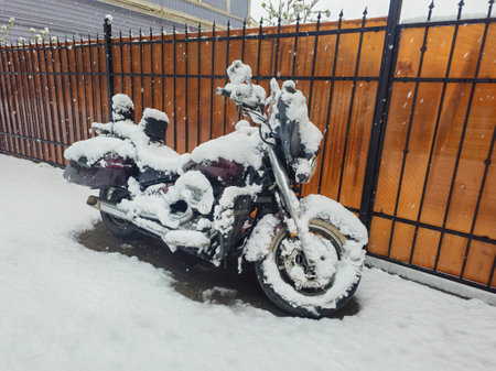 Motorcycle under the snow in the yard of the house. Snow covered motorcycle at the roadside.の写真素材