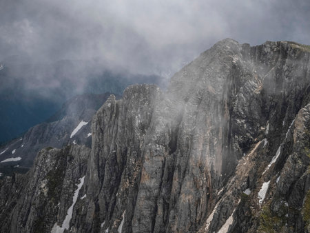 Dramatic fog among giant rocky mountains. Low clouds and beautiful rockies. Mountains in the haze....