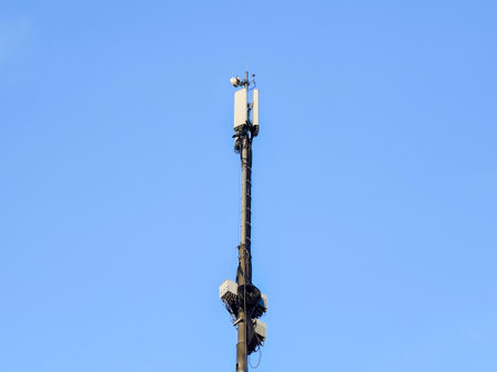 Mobile phone antenna, telecommunication tower in the center of a blue sky, cell tower, transmitter
