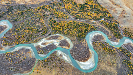 Picturesque autumn landscape from above, with a winding turquoise mountain river. Landscape is...