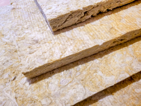 Close up stacked mineral wool insulation panels are ready for installation at a construction site. These panels will ensure thermal and acoustic efficiency in the building project.の写真素材