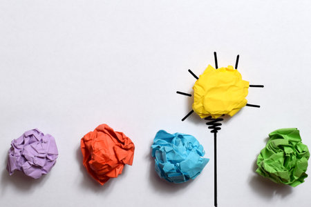 Colorful crumpled paper balls and light bulb as creative conceptの写真素材