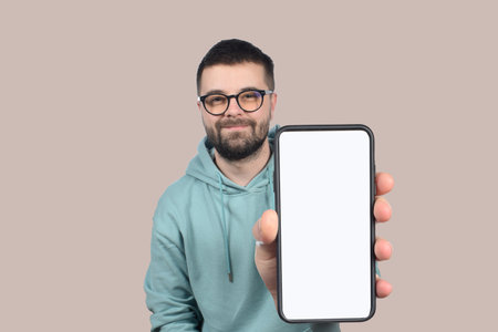 cute young man in glasses shows phone with blank white screen